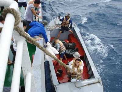 Những món quà tết được chuyển xuống xuồng đưa vào nhà giàn trong điều kiện sóng to, gió lớn.