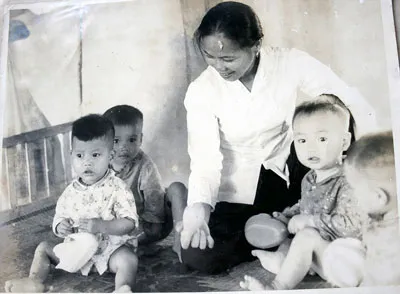 Cô giáo Thử chăm sóc các bé thời chiến tranh. Ảnh: Chụp lại từ ảnh tư liệu gia đình.