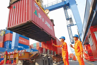 Bốc dỡ hàng xuất khẩu lên tàu tại Tân Cảng Cát Lái sáng 23-1 (mùng 1 Tết). Ảnh: Kim Ngân