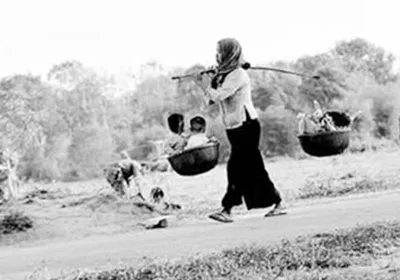 Bên kia đòn gánh là thúng mủng hàng quà, bên này là gánh con đi suốt cuộc đời. Ảnh: T.L.