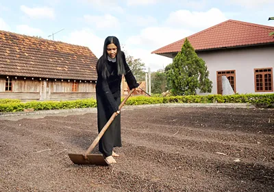 Nhiều gia đình trong buôn đổi đời nhờ trồng cà phê. (Trong ảnh: Chị H’len đang phơi cà phê).
