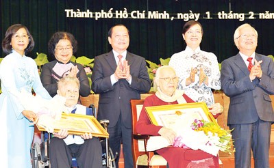 Ho Chi Minh City Party chief Le Thanh Hai (standing, C) and other city leaders congratulate two individuals (seated) receiving Party and State awards on February 1, 2012 (Photo: Viet Dung)
