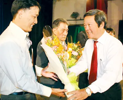 Chủ tịch Liên đoàn Lao động TPHCM Nguyễn Huy Cận tặng hoa chúc mừng những đảng viên là công nhân tiêu biểu trong buổi giao lưu “Gương sáng đảng viên” chiều 2-2 tại Cung văn hóa Lao động.