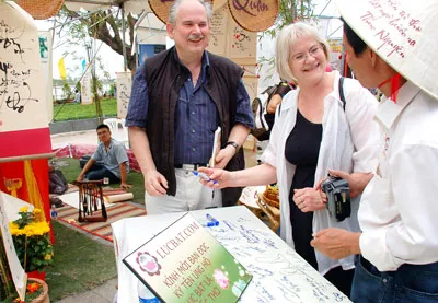 Hai du khách người Đức ký tên ủng hộ thơ lục bát là quốc thơ Việt Nam trong ngày thơ TPHCM. Ảnh: T.VÂN