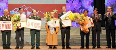 Phó Thủ tướng Nguyễn Thiện Nhân (bìa phải) và Phó Tổng Biên tập Báo SGGP Nguyễn Tấn Phong (thứ hai, phải qua) tặng Bằng tri ân, Kỷ niệm chương và hoa cho các nhà tài trợ. Ảnh: An Dung