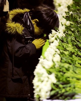 A boy prays at an altar during an official memorial service in Rikuzentakata city, Iwate prefecture on March 11, 2012. (Photo: AFP)