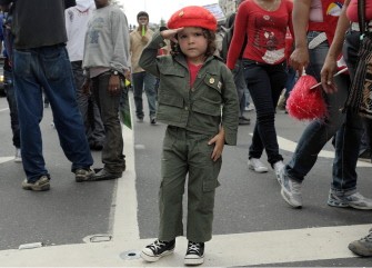 A little girl dressed in the Venezuelan reserve costume salutes during a rally in Caracas on March 10, 2012 to wish President Hugo Chavez a prompt recovery from cancer surgery.