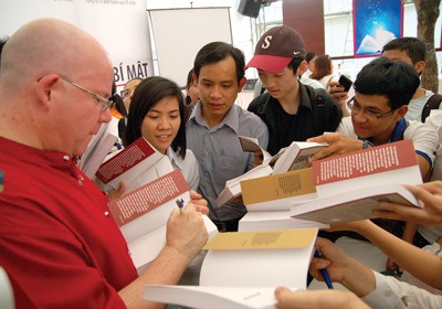 A foreign writer signs copies of his edition for readers. (Photo: SGGP)