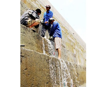 Workers examining a leak on the Song Tranh 2 hydropower plant reservoir in the central province of Quang Nam on March 21 (Photo: SGGP)