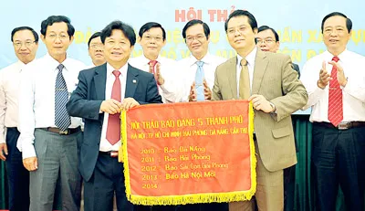 Tổng Biên tập Báo SGGP Trần Thế Tuyển trao cờ cho Tổng Biên tập Báo Hà Nội Mới Tô Quang Phán - đơn vị đăng cai hội thảo năm 2013.