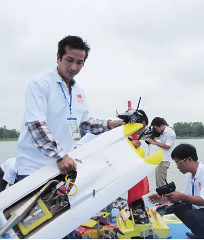 Các thành viên đưa tàu thủy mô hình tham gia biểu diễn trên sông Hương.