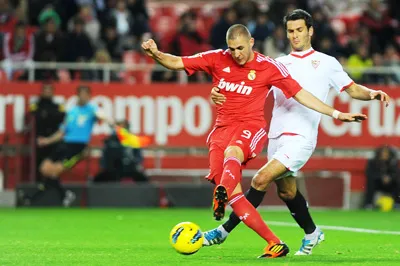 Karim Benzema (trái, Real Madrid) kiểm soát bóng trước Emir Spahic (Sevilla)