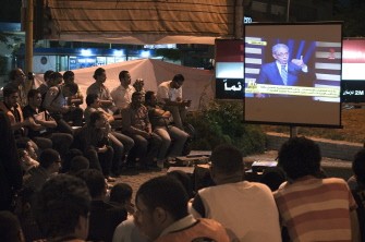Egyptians watch presidential hopeful candidate moderate Islamist, Abdelmoneim Abul Fotouh (not seen) and former Arab League General Secretary, Amr Mussa speaking during a television live debate at a public screening in Cairo on May 10, 2012.
