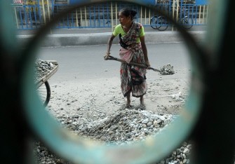 Labourers are seen working on road construction in Siliguri on May 10, 2012. Seeking to spur growth further, India' central bank in April lowered interest rates for the first time in three years, with a bigger-than-forecast 50 basis points cut in interest rates.