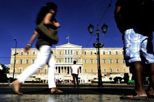 People walk by the Greek parliament in Athens. Greece's radical leftist Syriza party is set to start trying to build an anti-austerity cabinet and prevent fresh elections, a day after the conservatives failed to form a coalition government.
