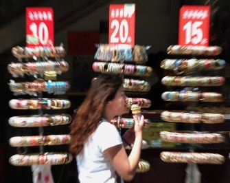 A woman walks past a jewellery store display at the Wangfujing shopping street in Beijing on May 16, 2012.