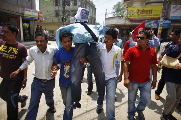 Activists of Nepali Congress-affiliated Nepal Students Union carry an effigy of Prime Minister Baburam Bhattarai before burning it as they demand his resignation in Katmandu, Nepal, Monday, May 28, 2012.