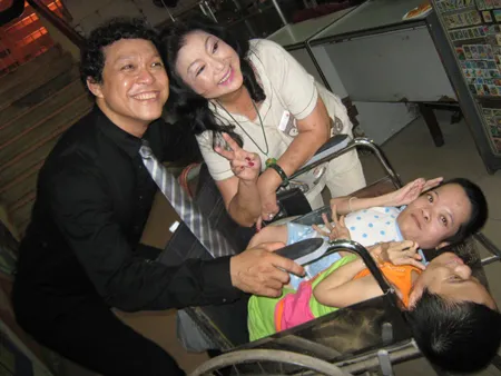 Nhiếp ảnh gia Nguyễn Á và nghệ sĩ Kim Cương chụp hình kỷ niệm cùng chị em khuyết tật Thủy và Bố đến từ Nghệ An. Ảnh: Đình Dư