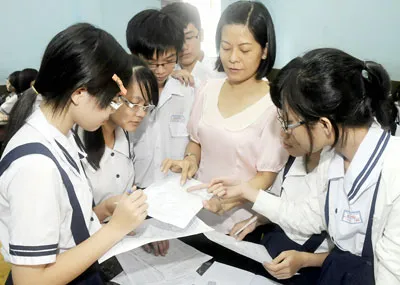 Giáo viên Trường THCS Kim Đồng quận 5 hướng dẫn các em học sinh lớp 9 đăng ký nguyện vọng xét tuyển vào lớp 10 năm học 2012 - 2013. Ảnh: MAI HẢI
