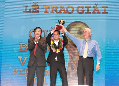 Đồng chí Nguyễn Tấn Phong (bên trái) - Phó Tổng biên tập phụ trách Báo SGGP và ông Lê Hùng Dũng - Phó Chủ tịch VFF trao Quả bóng vàng cho tiền vệ Nguyễn Thành Lương.