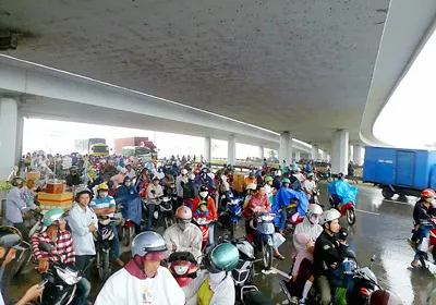 Núp mưa giữa lòng đường bên dưới cầu vượt