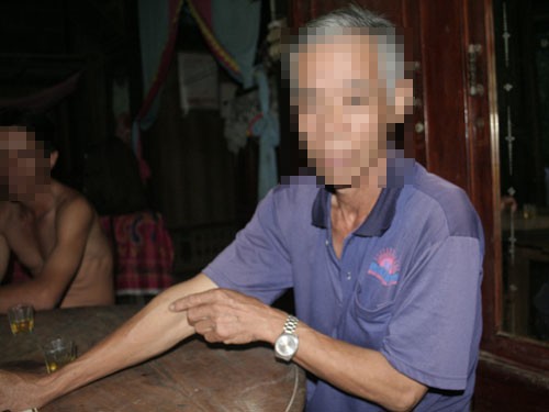 An infected HIV man in Mo Cay Nam District in Ben Tre Province pointing at an injection received from Be, the local practitioner