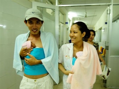 A young couple looks happy after the wife gives birth to twins safe and sound.