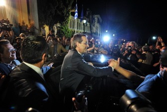 New Democracy party leader Antonis Samaras (Bottom C) greets supporters following a press conference at Zappion Hall in central Athens after his party came first in Greece's national election, June 17, 2012
