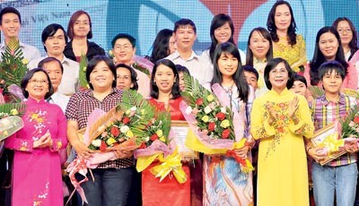 Nguyen Thi Thu Ha, vice-secretary of HCMC Party Committee (front row, 2nd R) and Than Thi Thu, head of Education and Propaganda for Party Committee (front row, Ex L) present awards to journalists (Photo: SGGP)