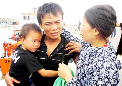 Fisherman Nguyen Van Suu returns to his wife and son, who came to Da Nang City to see him, from his hometown in Quang Binh Province (Photo: SGGP)