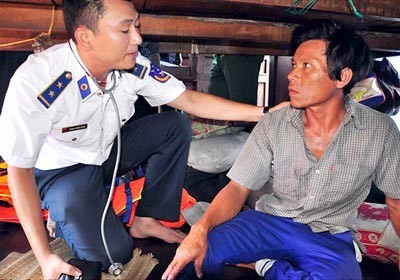 A medic of the marine police force checks a fisherman after the rescue (Photo: SGGP)
