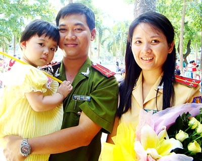 The happy family of Nguyen Quoc Tuan, a policeman in Ward 7 in District 3, and Chu Thi Thu Thuy, an employee of the HCMC Road and Railway Traffic Police Department, is honored at the ceremony. (Photo: Sggp)