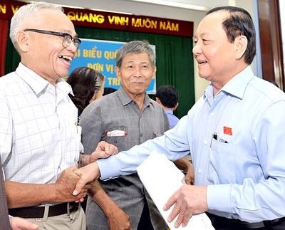 Le Thanh Hai, secretary of the HCMC Party Committee (R) meets voters in District 5. (Photo: Sggp)