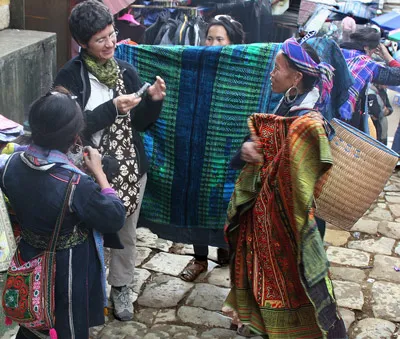 Phụ nữ H’Mông chào bán thổ cẩm cho du khách.