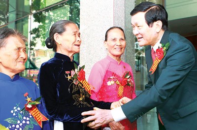 State President Truong Tan Sang (R) pays tribute to Vietnamese heroic mothers at the meeting (Photo: Sggp)