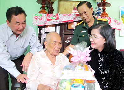 Nguyen Thi Thu Ha, deputy secretary of the HCMC Party Committee (R) offers gifts to Vietnamese heroic mother Nguyen Thi Co in Hoc Mon District (Photo: SGGP)