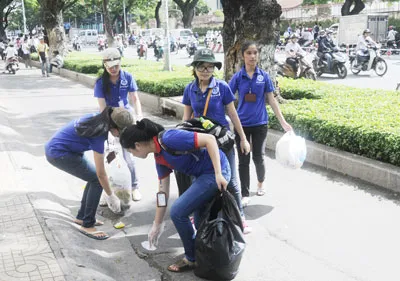Thanh niên tình nguyện dọn dẹp vệ sinh trước các hội đồng thi trên đường Nguyễn Văn Cừ (quận 5). Ảnh: MAI HẢI