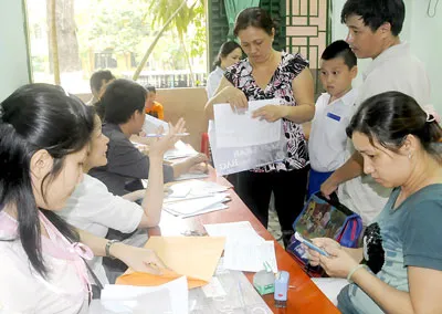 Phụ huynh học sinh nộp hồ sơ xét tuyển vào lớp 6 năm học 2012 - 2013 tại Trường THCS Hồng Bàng, quận 5,TPHCM. Ảnh: MAI HẢI