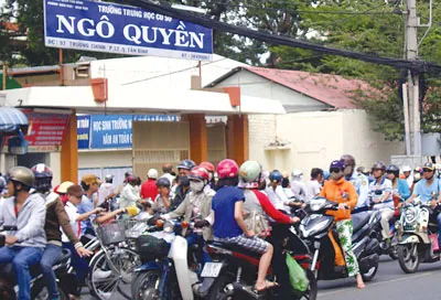 Phụ huynh lấn chiếm lòng lề đường chờ đón học sinh (ảnh chụp trước Trường THCS Ngô Quyền, đường Trường Chinh quận Tân Bình chiều 9-8).