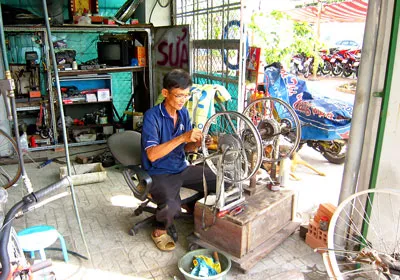 Anh Nguyễn Văn Thành mỗi ngày phải đi 9 cây số từ khu tạm cư An Lợi Đông đến chung cư Thạnh Mỹ Lợi quận 2 để làm nghề sửa xe. Ảnh: Huy Anh