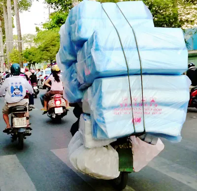 Xe máy chở hàng cồng kềnh trên đường Hùng Vương, quận 5.