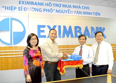 Eximbank representatives give money to knight Nguyen Van Minh Tien (2nd from the left).