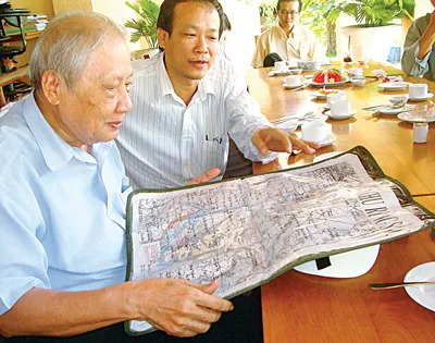 Ông Trần Hữu Phước (bìa trái) và tấm bản đồ quý về chiến khu Rừng Sác, Cần Giờ. Ảnh: A.M.