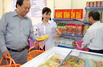 Người dân mua hàng bình ổn giá tại cửa hàng của Vissan. Ảnh: KIM NGÂN