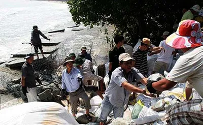 Người dân xã Hải Dương, thị xã Hương Trà, tỉnh Thừa Thiên – Huế chèn đá hộc khắc phục tạm thời tình trạng bờ biển sạt lở. Ảnh: Văn Thắng