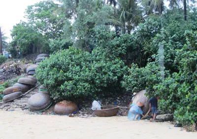 Ngư dân xã An Hòa, huyện Tuy An tranh thủ đẩy lại những chiếc thúng chai của mình lên lên bờ trước khi bão đến. Ảnh: Quốc Thắng