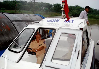 Cảnh sát đường sông Thừa Thiên – Huế kiểm tra, hướng dẫn các chủ thuyền hoạt động trên sông Hương ràng buộc phương tiện tránh bão số 8. Ảnh: Văn Thắng