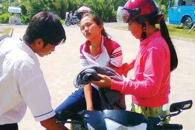 An unconscious student being taken by her parents to the hospital (Photo: SGGP)