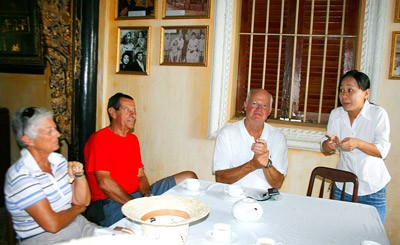 A tourist guide is introducing story and structure of Huynh Thuy Le ancient house in the Mekong delta province of Dong Thap ( Photo: SGGP)