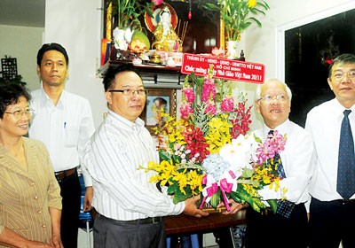 Chairman of the City People's Committee Le Hoang Quan (second from R) visits and offers flowers to the family of late Professor Vu Dinh Hoe (Photo: Mai Hai-SGGP)